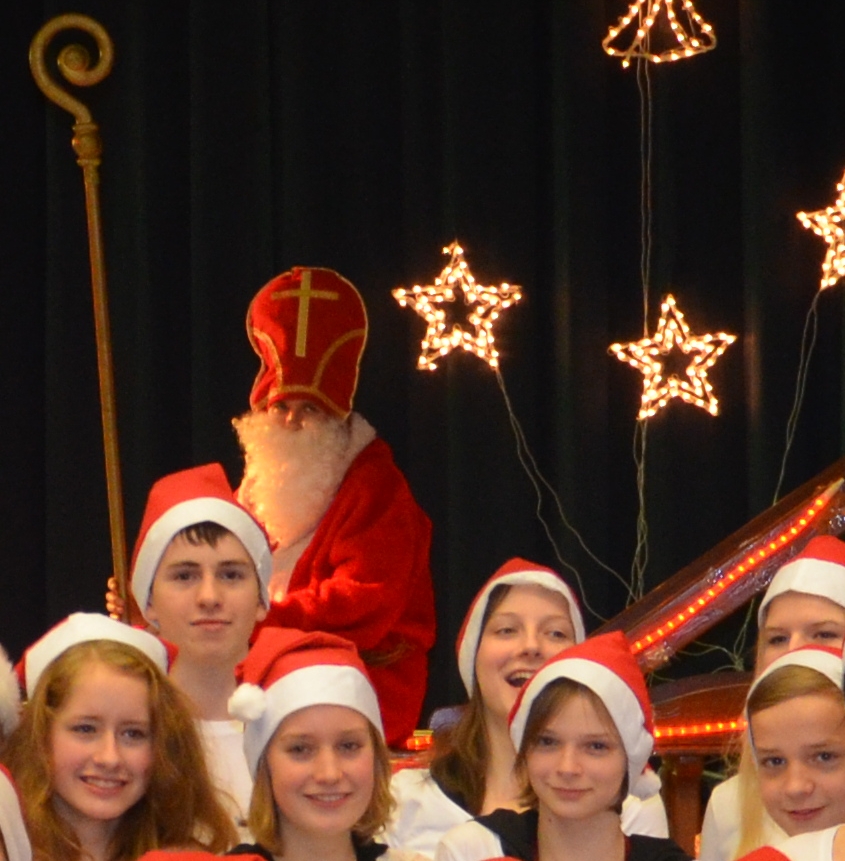 Köpfe mit Nikolausmützen, dahinter ein Nikolaus