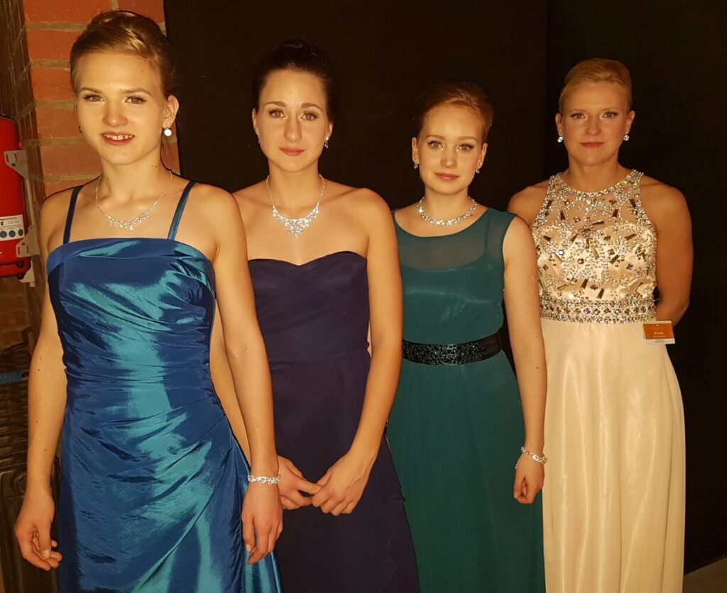 vier junge Damen in Ballkleidern
